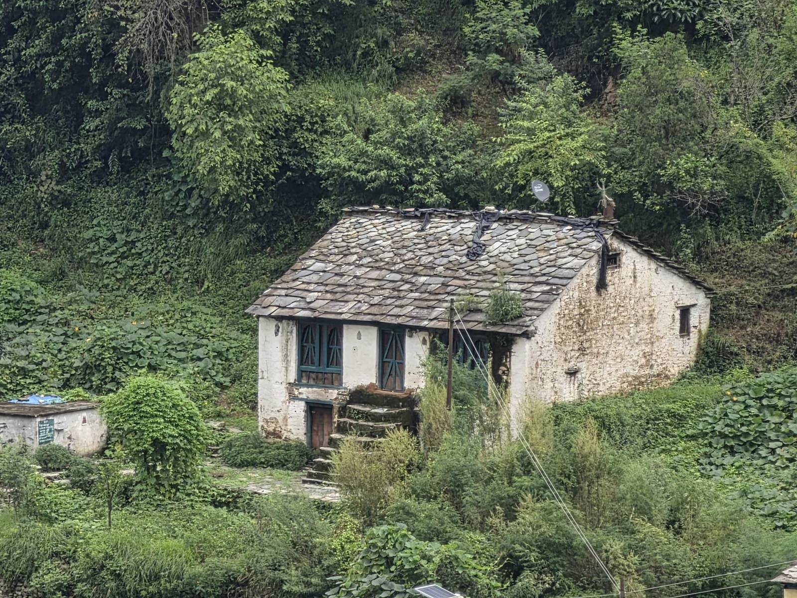 A traditional slate-roofed stone cottage tucked into the hillside near Hartola